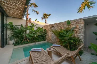 a backyard with a swimming pool and two chairs at Casa Vera - Delightful 1-Bedroom Villas in the Heart of Umalas in Canggu