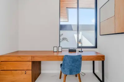 an office with a wooden desk and a blue chair at Casa Estella Stunning 2BR in Umalas Canggu in Kerobokan