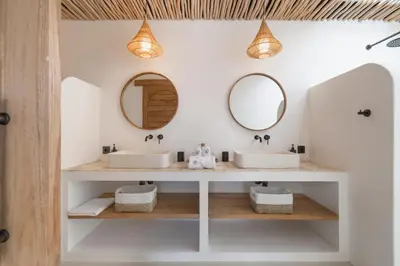 a bathroom with two sinks and two mirrors at Villa Casa Gaia 2 by BaliSuperHost in Kerobokan
