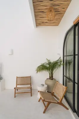 a patio with two chairs and a potted plant at Villa Casa Gaia 2 by BaliSuperHost in Kerobokan