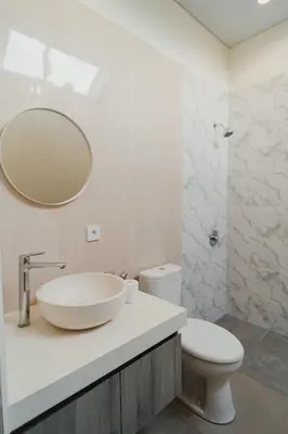 a bathroom with a sink and a toilet and a mirror at D'Leafy Seminyak in Seminyak