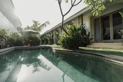 a swimming pool in front of a house at D'Leafy Seminyak in Seminyak
