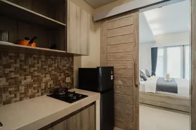 a kitchen with a stove and a bed in a room at D'Leafy Seminyak in Seminyak