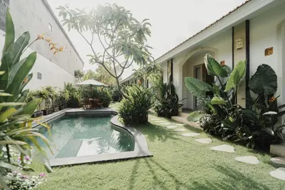 a courtyard with a swimming pool and plants at D'Leafy Seminyak in Seminyak