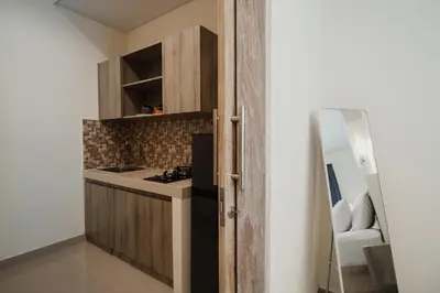 a small kitchen with a stove top oven next to a door at D'Leafy Seminyak in Seminyak