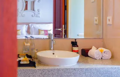 a bathroom with a sink and a mirror and towels at The Springs Villas Jimbaran in Jimbaran