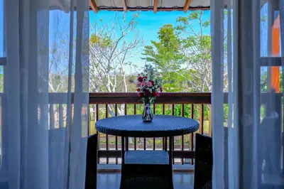 a table with a vase of flowers on a balcony at The Springs Villas Jimbaran in Jimbaran