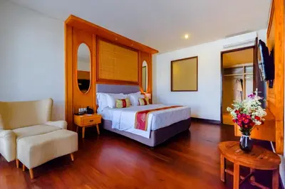 a hotel room with a bed and a chair at The Springs Villas Jimbaran in Jimbaran
