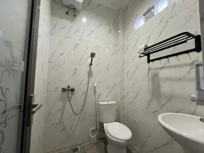 a bathroom with a shower and a toilet and a sink at Kubu Celagi Manis in Jimbaran