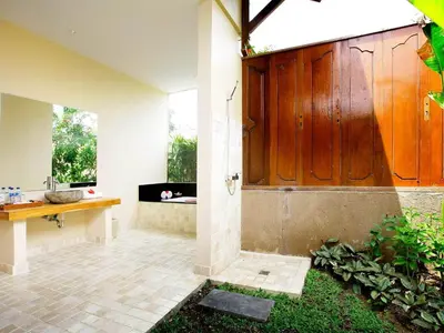 a large wooden door in the middle of a room at Villa Cokelat in Canggu