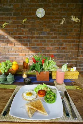 a plate of food on a table with a plate of food at Villa Cokelat in Canggu