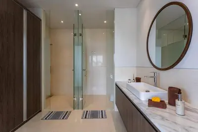 a bathroom with a sink and a shower with a mirror at Pristine & Modern Gem Luxury 3bd Villa in Umalas in Kerobokan