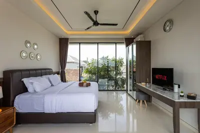 a bedroom with a large bed and a balcony at Pristine & Modern Gem Luxury 3bd Villa in Umalas in Kerobokan