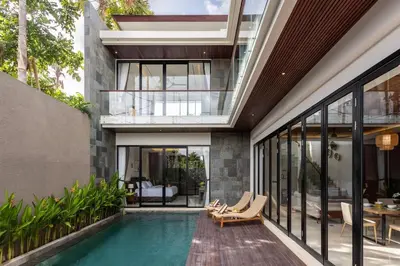 a house with a swimming pool and a patio at Pristine & Modern Gem Luxury 3bd Villa in Umalas in Kerobokan