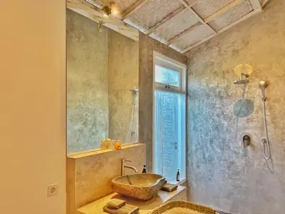 a bathroom with a stone sink and a shower at Villa Rocher - Modern 3 BR Villa Batu Belig 3 min beach in Seminyak