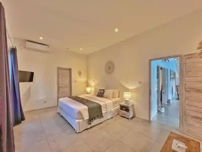 a large bedroom with a bed and a large window at Villa Rocher - Modern 3 BR Villa Batu Belig 3 min beach in Seminyak