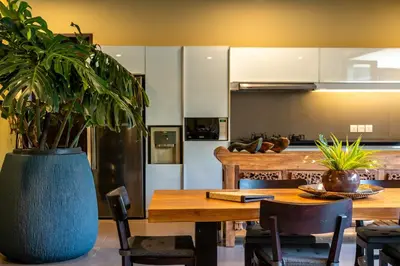 a kitchen with a wooden table with a potted plant at Villa Eleni - Your Private Oasis in Seminyak - A Hosted Luxury Boutique Villa in Seminyak