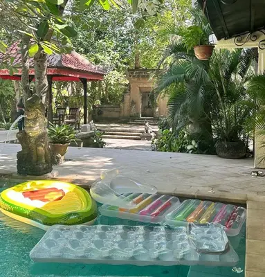 a pool with a frisbee and other items on it at Villa Gadja Bali in Jimbaran
