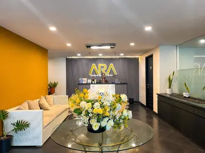 a living room with a couch and a table with flowers at Hotel ARA Legian in Legian