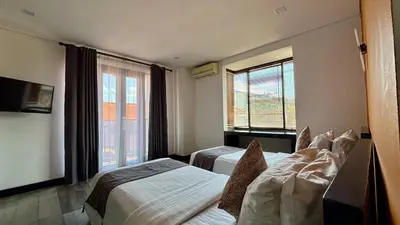 a hotel room with two beds and a window at Hotel ARA Legian in Legian