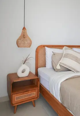 a bed with a nightstand next to a bed with a clock on it at Shanti Villa - 3BR Luxury in Seminyak in Badung