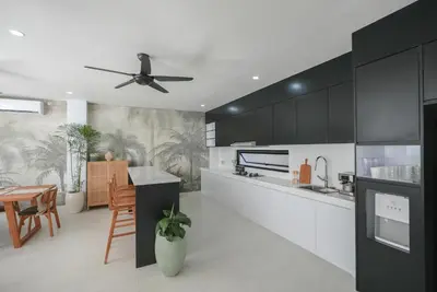 a kitchen with black cabinets and a ceiling fan at Shanti Villa - 3BR Luxury in Seminyak in Badung