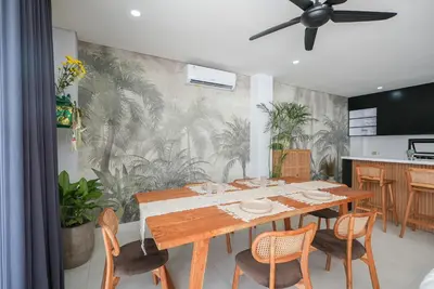a dining room with a table and some plants at Shanti Villa - 3BR Luxury in Seminyak in Badung