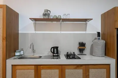 a kitchen counter with a sink and a stove at Eunoia Villa in Jimbaran