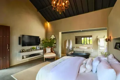 a bedroom with a large bed and a bathroom at Saanvi 2 BR Private Pool Villa in Canggu