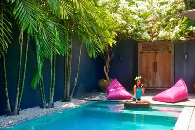 a little girl standing in a pool with pink pillows at Saanvi 2 BR Private Pool Villa in Canggu
