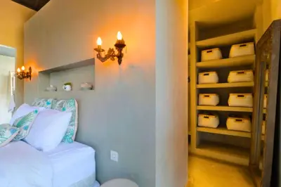 a bedroom with a white bed and a book shelf at Saanvi 2 BR Private Pool Villa in Canggu