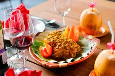 a table with a plate of food and glasses of wine at Bintarti 3 BR Private Pool Villa in Canggu