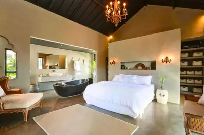a bedroom with a large bed and a bath tub at Bintarti 3 BR Private Pool Villa in Canggu