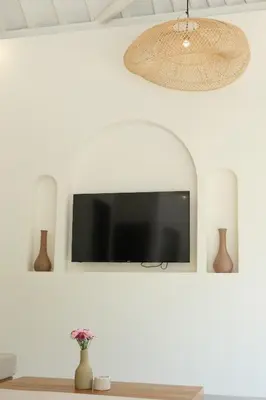 a flat screen tv hanging on a white wall at Uma dharma villas in Seminyak