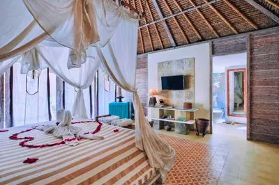 a bedroom with a bed with a canopy at Vanshika 1 BR Garden Villa Shared Pool in Sanur