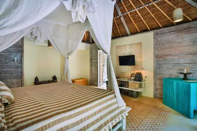 a bedroom with a bed and a television in it at Vanshika 1 BR Garden Villa Shared Pool in Sanur