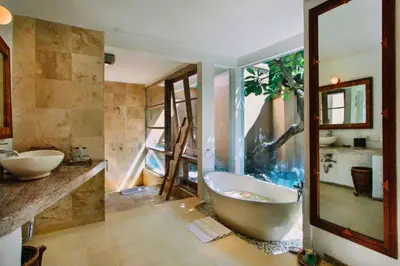 a bathroom with a large tub and a large mirror at Vanshika 1 BR Garden Villa Shared Pool in Sanur