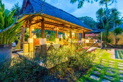 a pavilion with a table and chairs in a garden at Vainavi 1 BR Private Pool Villa in Sanur