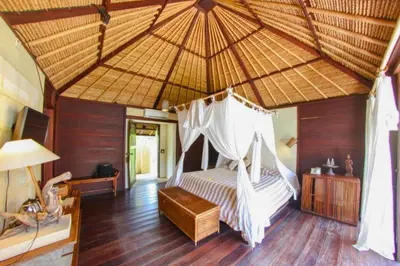 a bedroom with a bed with a mosquito net at Vainavi 1 BR Private Pool Villa in Sanur