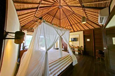 a bedroom with a canopy bed with a straw roof at Vainavi 1 BR Private Pool Villa in Sanur