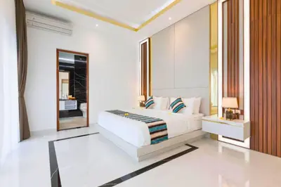 a white bedroom with a bed and a mirror at Lashana 3 BR Private Pool Villa in Legian