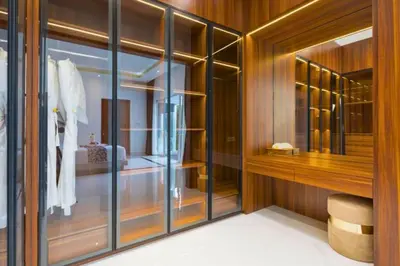 a walk in closet with wooden walls and glass doors at Nayana 4 BR Private Pool Villa in Legian