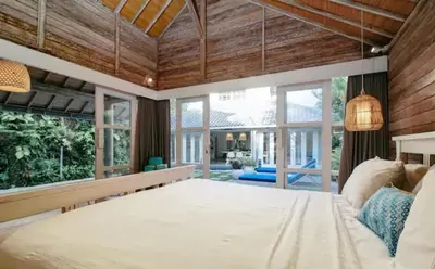 a large bedroom with a large bed and large windows at Villa 9C in Seminyak