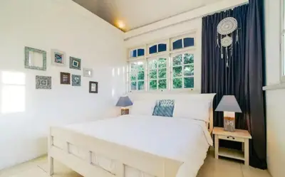 a white bedroom with a large bed and windows at Villa 9C in Seminyak