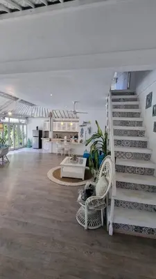 a room with a staircase and chairs and a living room at Villa 9C in Seminyak