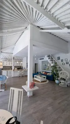 a living room with white ceilings and a table and chairs at Villa 9C in Seminyak