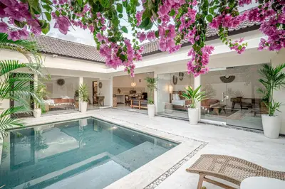 a swimming pool in the middle of a house with flowers at Villa Lemone 5 by Bali Villa Solutions in Seminyak