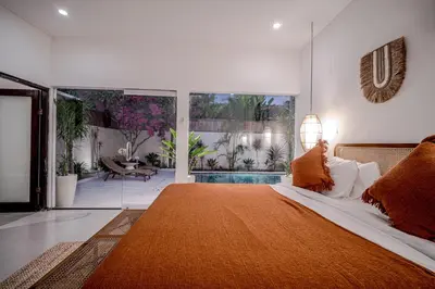 a bedroom with a large bed and a swimming pool at Villa Lemone 5 by Bali Villa Solutions in Seminyak