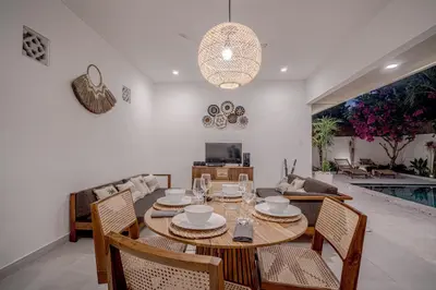 a dining room and living room with a table and chairs at Villa Lemone 5 by Bali Villa Solutions in Seminyak