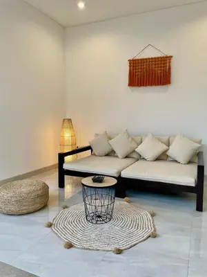 a living room with a couch and a table at CASA NOOA Kerobokan in Kerobokan